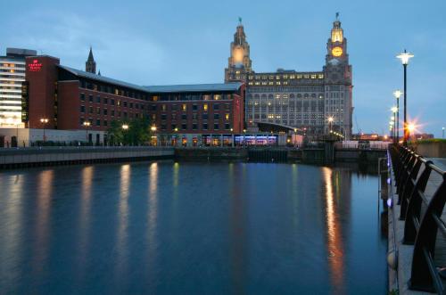 a river with buildings and a clock tower at night at Crowne Plaza Liverpool City Centre by IHG in Liverpool