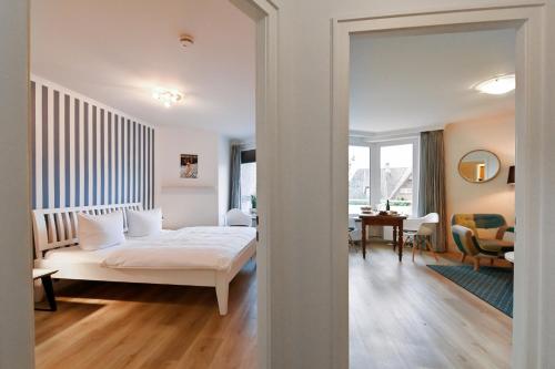 a bedroom with a bed and a living room at Kamperhof 51 in Westerland (Sylt)