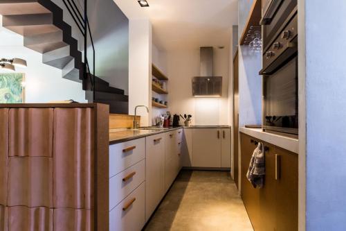 une cuisine avec des placards blancs et un escalier dans l'établissement JUNGLE KEYWEEK Townhouse with terrace and garden, à Biarritz