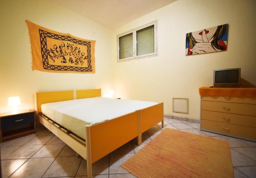 una camera con letto, TV e cassettiera di Casa Vacanza Tricarico a Gallipoli