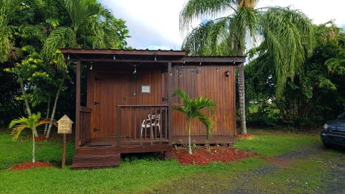a small wooden shed with a chair in the grass at Hacienda el Jibarito in San Sebastian