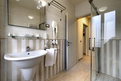 uma casa de banho com um lavatório e uma cabina de duche em vidro. em Domus Australia em Roma