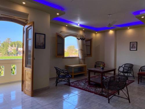 uma sala de estar com mesa e cadeiras e luzes azuis em Elsanosy Family Guest House - Luxor em Luxor