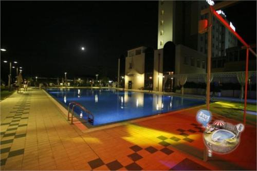 a large swimming pool at night in a city at Zanhotel Centergross in Bentivoglio