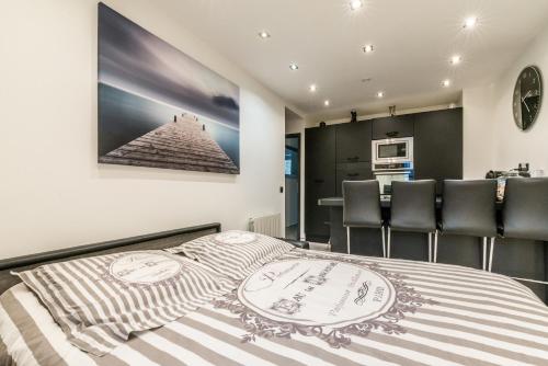 Cet appartement comprend une chambre avec un lit et des chaises ainsi qu'une cuisine. dans l'établissement Lac et Montagne, à Veyrier-du-Lac