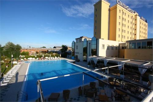 a large swimming pool in front of a hotel at Zanhotel Centergross in Bentivoglio
