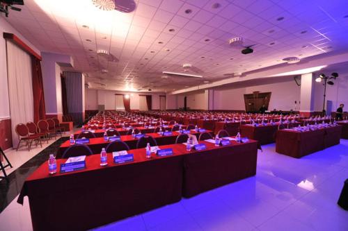 a large room with rows of tables and chairs at Zanhotel Centergross in Bentivoglio