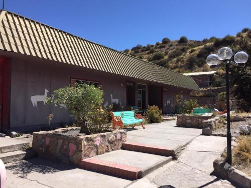 a building with a green bench in front of it at Hotel Las Vicuñas in Putre