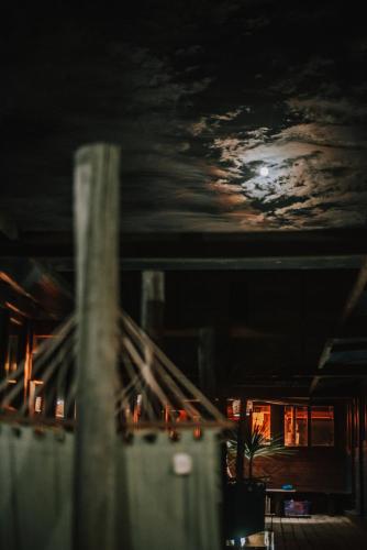 a view of the moon from a city at night at Mar de Fondo Hostel in Punta Del Diablo