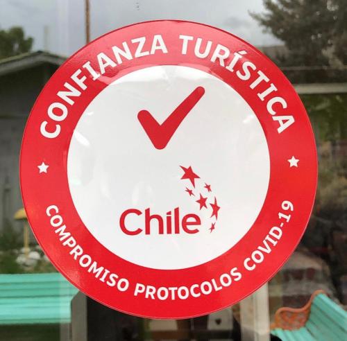 a red and white sign in a window at Hotel Las Vicuñas in Putre