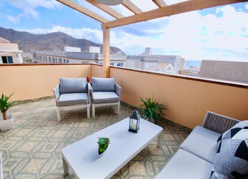 a patio with two chairs and tables on a balcony at Atlantic Sea in Gran Tarajal