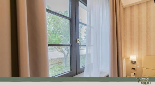 a window in a room with a view of a tree at Hotel Parco delle Querce in Crispiano