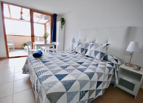 a bedroom with a bed with a blue and white quilt at Atlantic Sea in Gran Tarajal