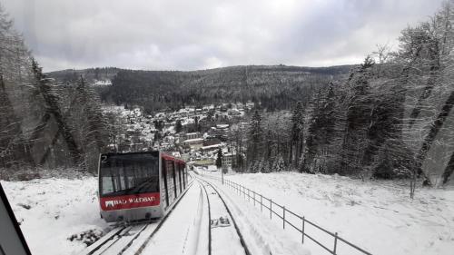 a train traveling down the tracks in the snow at Apartment Wildbad in Bad Wildbad