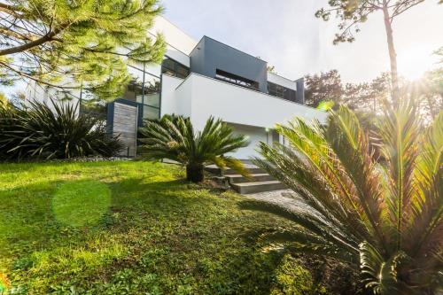 une maison moderne avec une cour verdoyante dans l'établissement OCTOPUS KEYWEEK Design villa on the Golf of Chiberta with heated pool, à Anglet