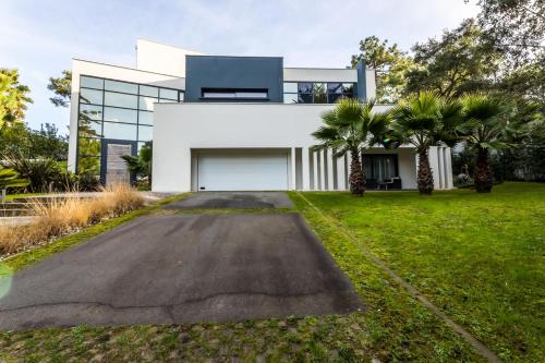 une maison avec une allée devant dans l'établissement OCTOPUS KEYWEEK Design villa on the Golf of Chiberta with heated pool, à Anglet