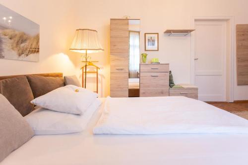 a bedroom with a white bed and a couch at Hübsches Privatzimmer mit Bad in Perchtoldsdorf