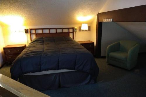 Habitación de hotel con cama y silla en Unit 101 - Treeloft 3 Bedroom Villa, en Four Seasons