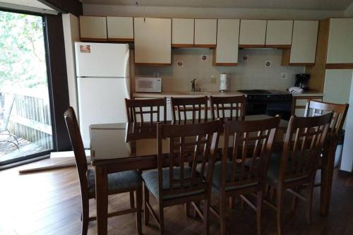 cocina con mesa, sillas y nevera en Unit 101 - Treeloft 3 Bedroom Villa, en Four Seasons