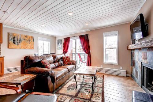 布雷肯里奇Panorama Alpine Condo: Hip Downtown Location的带皮沙发和壁炉的客厅