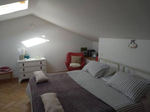 a bedroom with a bed with pillows and a chair at Civico 5 in Assisi