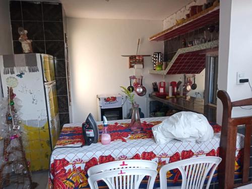 a kitchen with a table and two chairs and a refrigerator at Aconchego em Garanhuns in Garanhuns