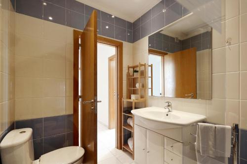 a bathroom with a toilet and a sink at Luz, Sol e Praia in Portimão