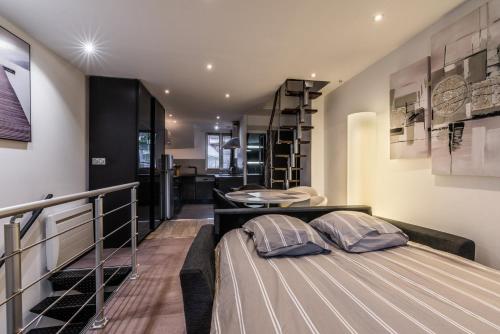 a bedroom with a bed and a balcony with a table at Le grand duplex du lac in Veyrier-du-Lac