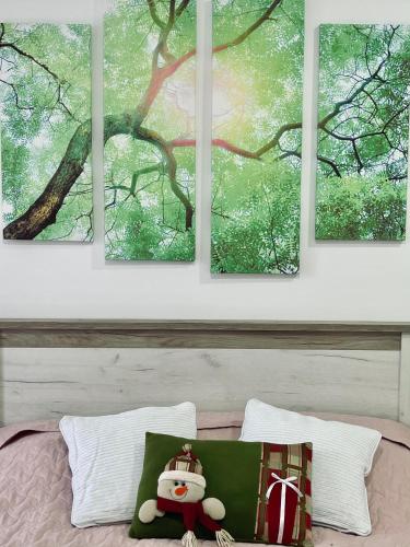 four paintings on a wall above a bed at Lake View Tašić in Veliko Gradište