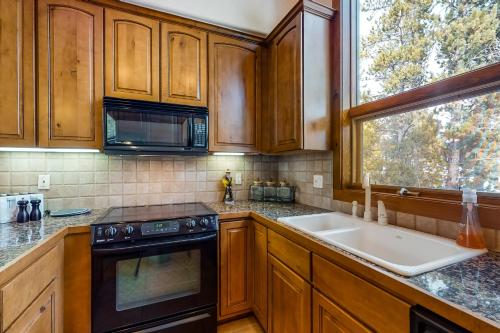 una cucina con armadi in legno, lavandino e finestra di Snowflake Retreat a Breckenridge