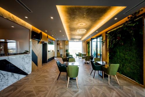 a restaurant with green chairs and tables in a room at Hotel Bonsai in Tirana