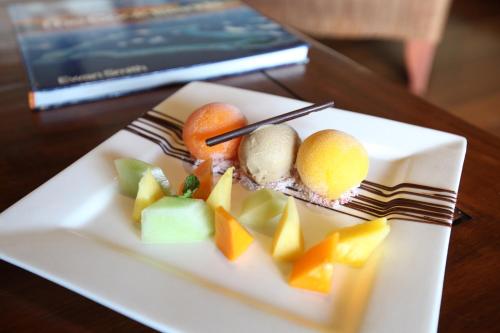 a white plate with fruit on a table at Pacific Resort Aitutaki - Adults Only in Arutanga