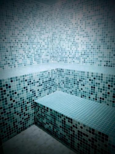 a bathroom with a green and white tiled wall at Pousada Sitieto Voitov in Aluminio