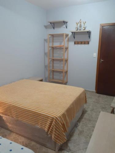 a bedroom with a bed and a book shelf at Pousada Sitieto Voitov in Aluminio