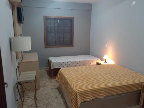 a hotel room with two beds and a window at Pousada Sitieto Voitov in Aluminio