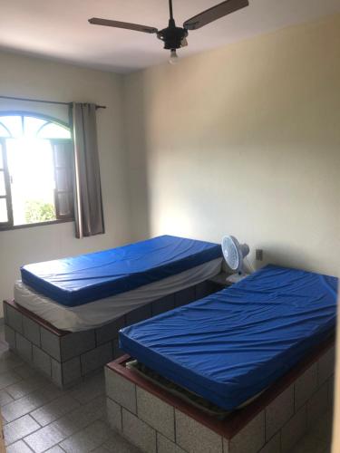 Cette chambre dispose de 2 lits et d'un ventilateur de plafond. dans l'établissement De Angelis - Casa de praia em Piuma com WI-FI, à Piúma