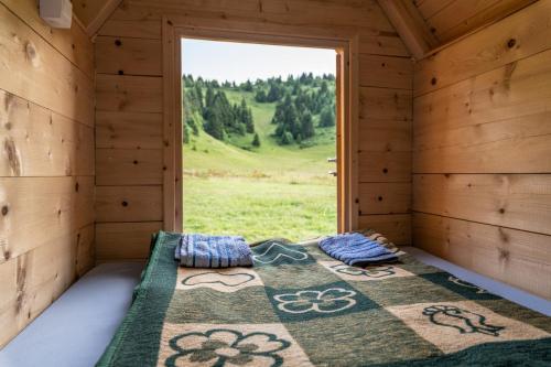 uma cama num quarto de madeira com uma janela em Kamp Janketic em Kolašin