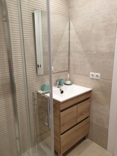 un baño con lavabo y espejo en Apartamento en la mejor zona de la Sierra junto a los remontes Reformado en 2021, en Sierra Nevada