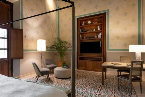 a bedroom with a bed and a desk and a table at Hacienda San Antonio Hool in Mérida