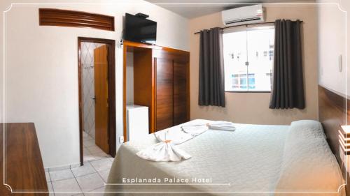 1 dormitorio con cama y ventana en Esplanada Palace Hotel, en Barra do Garças