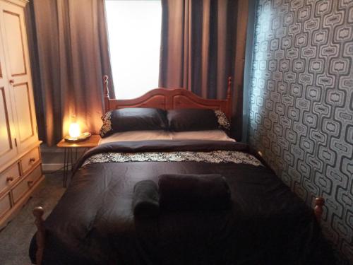 a bedroom with a large bed with a window at Summerhill, Wrexham - Key Worker friendly in Wrexham