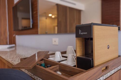 a kitchen with a coffee dispenser on a counter at Sensira Resort & Spa Riviera Maya All Inclusive in Puerto Morelos