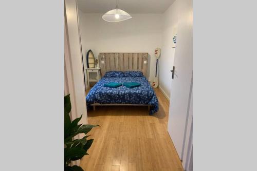 une chambre avec un lit avec une couette bleue dans l'établissement Trouville-Apt rénové-Balcon magnifique vue mer, à Trouville-sur-Mer