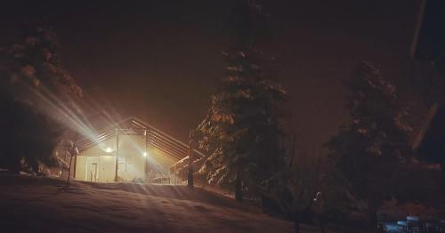 a building with lights in the snow at night at Hacienda Guster in Ritopek