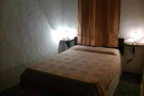 Un dormitorio con una cama con dos luces. en Casa ideal para descansar Piriápolis, en Piriápolis