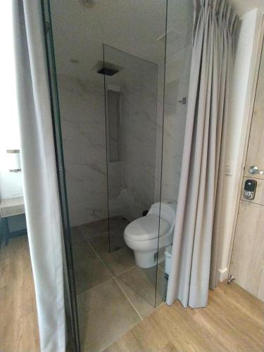 a bathroom with a toilet and a glass shower at Urban Heights Bogota in Bogotá