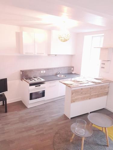 eine weiße Küche mit Herd und Spüle in der Unterkunft Charmant Logement en centre ville à Vierzon in Vierzon
