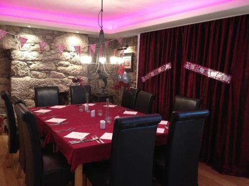 a dining room with a table with red table cloth at The Waterwheel in St Austell