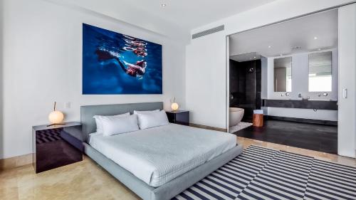a bedroom with a king sized bed and a bathroom at Avalon - 801 Top Sky Bar Pool 3 BR in Amapas in Puerto Vallarta