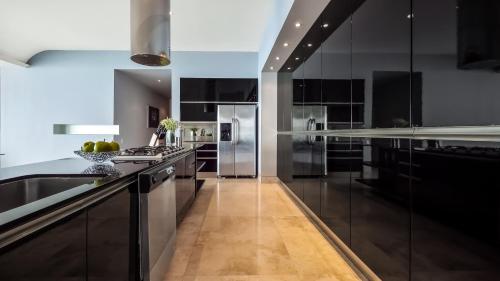 a kitchen with black cabinets and stainless steel appliances at Avalon - 801 Top Sky Bar Pool 3 BR in Amapas in Puerto Vallarta